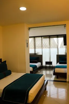 a bedroom with two beds and a large window at hotel medellin gold in Medellín