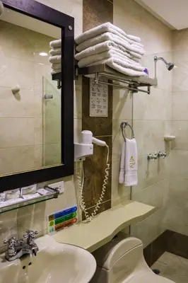 a bathroom with a sink and a mirror and towels at hotel medellin gold in Medellín