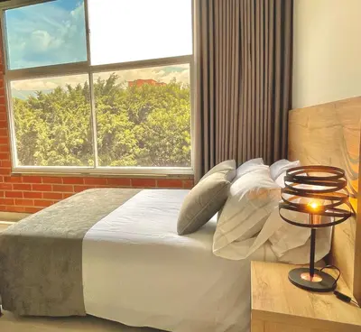 a bedroom with a large bed and a window at Apartamento en Laurels Medellín in Medellín