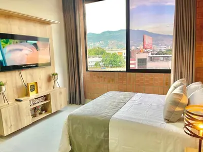 a bedroom with a large bed and a large window at Apartamento en Laurels Medellín in Medellín