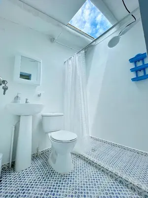 a white bathroom with a toilet and a sink at Hermosa Casa frente al Río in San Rafael