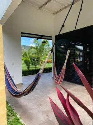 a hammock hanging from a house with a patio at Extraordinaria casa con piscina y pura naturaleza Honda in Honda