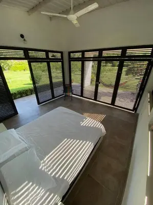a bedroom with a bed in a room with windows at Extraordinaria casa con piscina y pura naturaleza Honda in Honda
