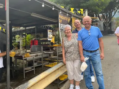 a man and a woman standing in front of a food stand at Gaston2 in Medellín