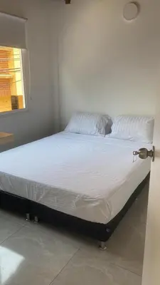a bed with white sheets and pillows in a room at Gaston2 in Medellín