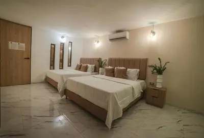 two beds in a large room with two at HOTEL BALI AT POBLADO in Medellín