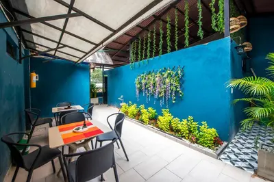 a restaurant with a blue wall with plants at HOTEL BALI AT POBLADO in Medellín