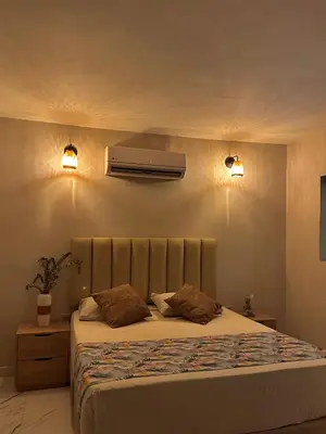 a bedroom with a bed and a air conditioner on the wall at HOTEL BALI AT POBLADO in Medellín