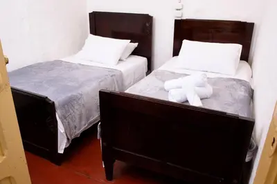 two beds with a teddy bear sitting on top of them at Casa típica Salamineña in Salamina