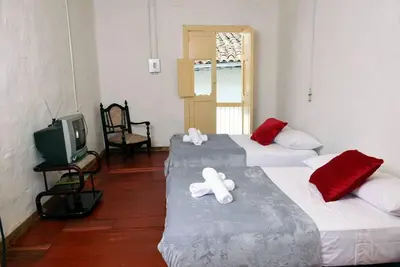 two beds in a room with a tv and a room with two white bears at Casa típica Salamineña in Salamina
