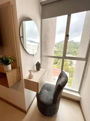 a room with a chair and a table and a mirror at Espectacular vista cerca a cable plaza con Piscina in Manizales