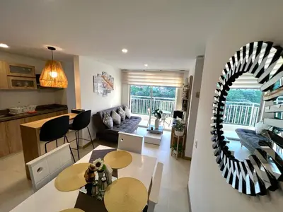a living room with a table and a dining room at Espectacular vista cerca a cable plaza con Piscina in Manizales