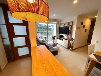 a living room with a table and a living room with a television at Espectacular vista cerca a cable plaza con Piscina in Manizales