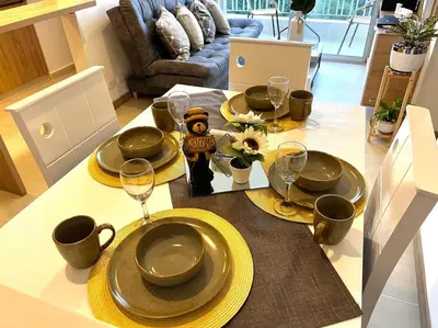 a dining room table with plates and wine glasses at Espectacular vista cerca a cable plaza con Piscina in Manizales
