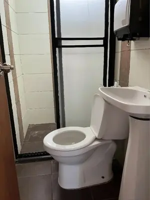 a bathroom with a toilet and a sink at Aparta Suite Torre De Prado Penthouse in Medellín