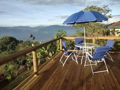 a deck with a table and chairs and an umbrella at Finca Emilio in Fredonia