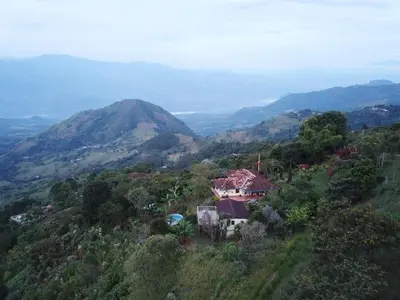 a house on a hill with a mountain in the background at Finca Emilio in Fredonia
