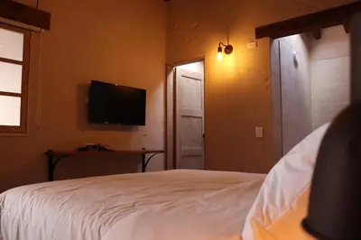 a bedroom with a bed and a flat screen tv at Valerio Hotel Boutique in Marinilla