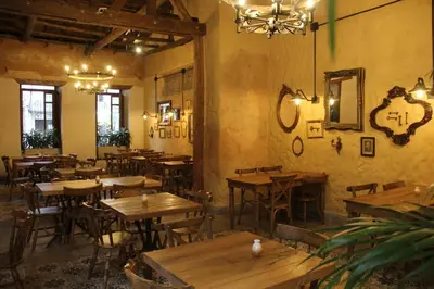an empty restaurant with wooden tables and chairs at Valerio Hotel Boutique in Marinilla