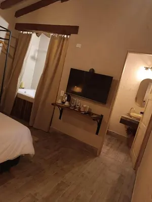 a room with a bed and a television and a table at Valerio Hotel Boutique in Marinilla