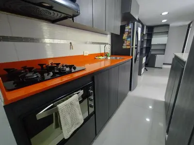 a kitchen with a stove with an orange counter top at RentalsOP AN01 Apto cerca al lleras con balcon y piscina climatizada, cerca a provenza, ubicado min del aeropuerto in Medellín