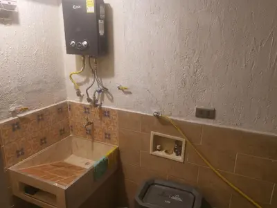 a bathroom with a toilet with a phone on the wall at La Lunar un espacio ideal para trabajar y conocer Medellín in Medellín