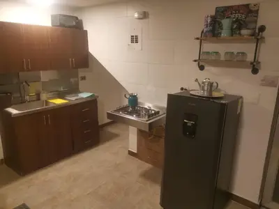 a kitchen with a black refrigerator and a sink at La Lunar un espacio ideal para trabajar y conocer Medellín in Medellín