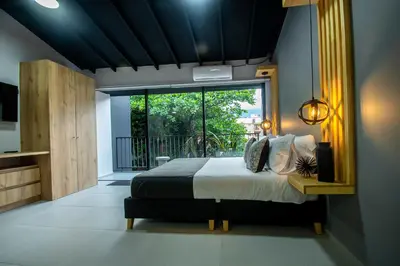 a bedroom with a bed and a large window at Barcelo Coliving in Medellín