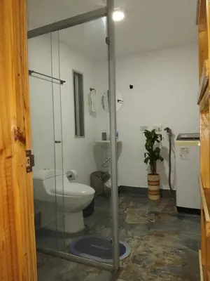 a bathroom with a toilet and a glass shower door at Los balconesll in Medellín