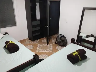 a room with two beds and a mirror at Los balconesll in Medellín