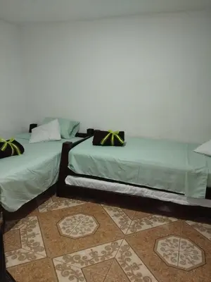 two beds sitting next to each other in a room at Los balconesll in Medellín