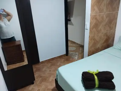 a woman taking a picture of a bed in a mirror at Los balconesll in Medellín