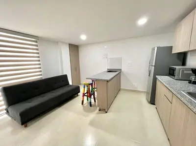 a living room with a black couch in a kitchen at Bonito apartaestudio /manizales in Manizales