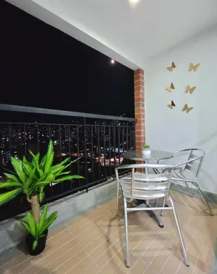 a table and a chair on a balcony with a view at Modern High-Rise 2/2 Apartment with City View. in Sabaneta