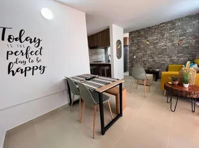a living room with a table and chairs and a kitchen at Apto Nuevo, Tranquilo, Bonito, 5 min Plaza Principal in Guatapé