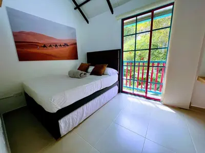 a bedroom with a bed and a large window at Apto Nuevo, Tranquilo, Bonito, 5 min Plaza Principal in Guatapé