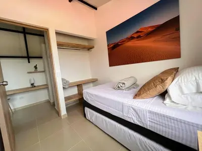 a bedroom with a bed with a painting on the wall at Apto Nuevo, Tranquilo, Bonito, 5 min Plaza Principal in Guatapé