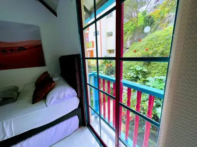 a small room with a bed and a window at Apto Nuevo, Tranquilo, Bonito, 5 min Plaza Principal in Guatapé