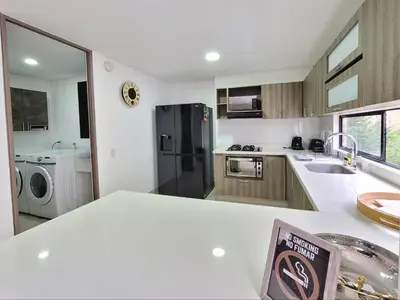 a kitchen with a black refrigerator and a sink at New Luxury 3 Bedroom Apartment in Great Area. in Medellín