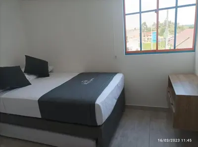 a bedroom with a bed in a room with a window at Apto Nuevo, Tranquilo,Bonito,5 min Plaza Principal in Guatapé