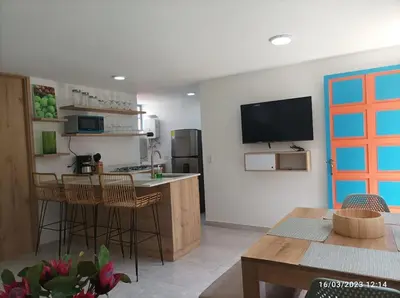 a kitchen with a table and chairs and a television at Apto Nuevo, Tranquilo,Bonito,5 min Plaza Principal in Guatapé
