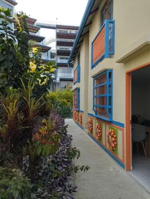 a building with blue windows and plants in a courtyard at Apto Nuevo, Tranquilo,Bonito,5 min Plaza Principal in Guatapé