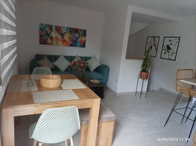a living room with a table and a blue couch at Apto Nuevo, Tranquilo,Bonito,5 min Plaza Principal in Guatapé