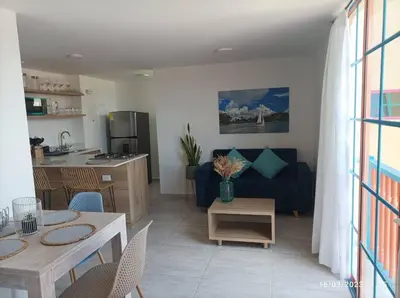 a kitchen and a living room with a couch and a table at Apto Nuevo, Tranquilo, Bonito, 5 min Plaza Principal in Guatapé
