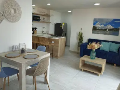 a kitchen and a living room with a table and chairs at Apto Nuevo, Tranquilo, Bonito, 5 min Plaza Principal in Guatapé