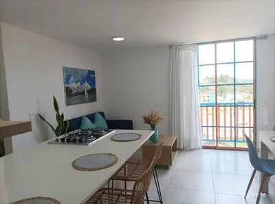 a kitchen with a white counter and a table with chairs at Apto Nuevo, Tranquilo, Bonito, 5 min Plaza Principal in Guatapé