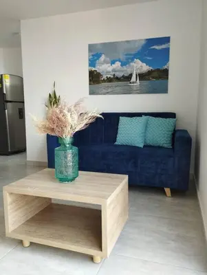 a living room with a blue couch and a coffee table at Apto Nuevo, Tranquilo, Bonito, 5 min Plaza Principal in Guatapé