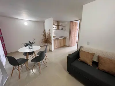 a living room with a couch and a table and chairs at Apto Nuevo, Tranquilo a 5 min Plaza Principal in Guatapé