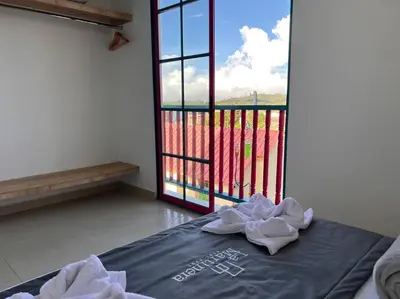 a room with a bed with a view of a window at Apto Nuevo, Tranquilo a 5 min Plaza Principal in Guatapé
