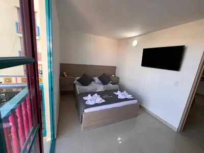 a bedroom with a bed and a flat screen tv at Apto Nuevo, Tranquilo a 5 min Plaza Principal in Guatapé